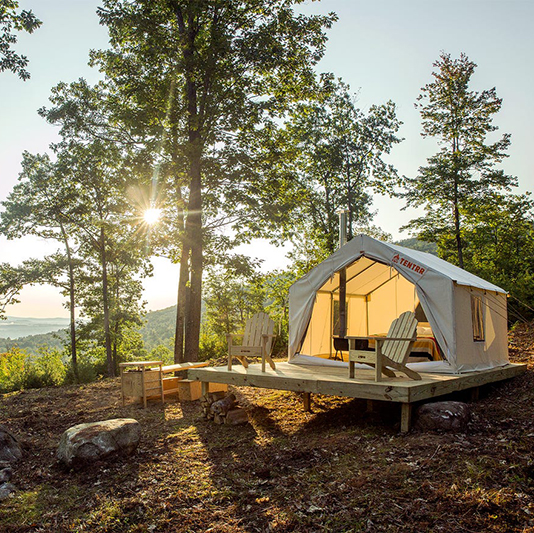 Beautiful camping site with the sun rising over the mountains behind it.