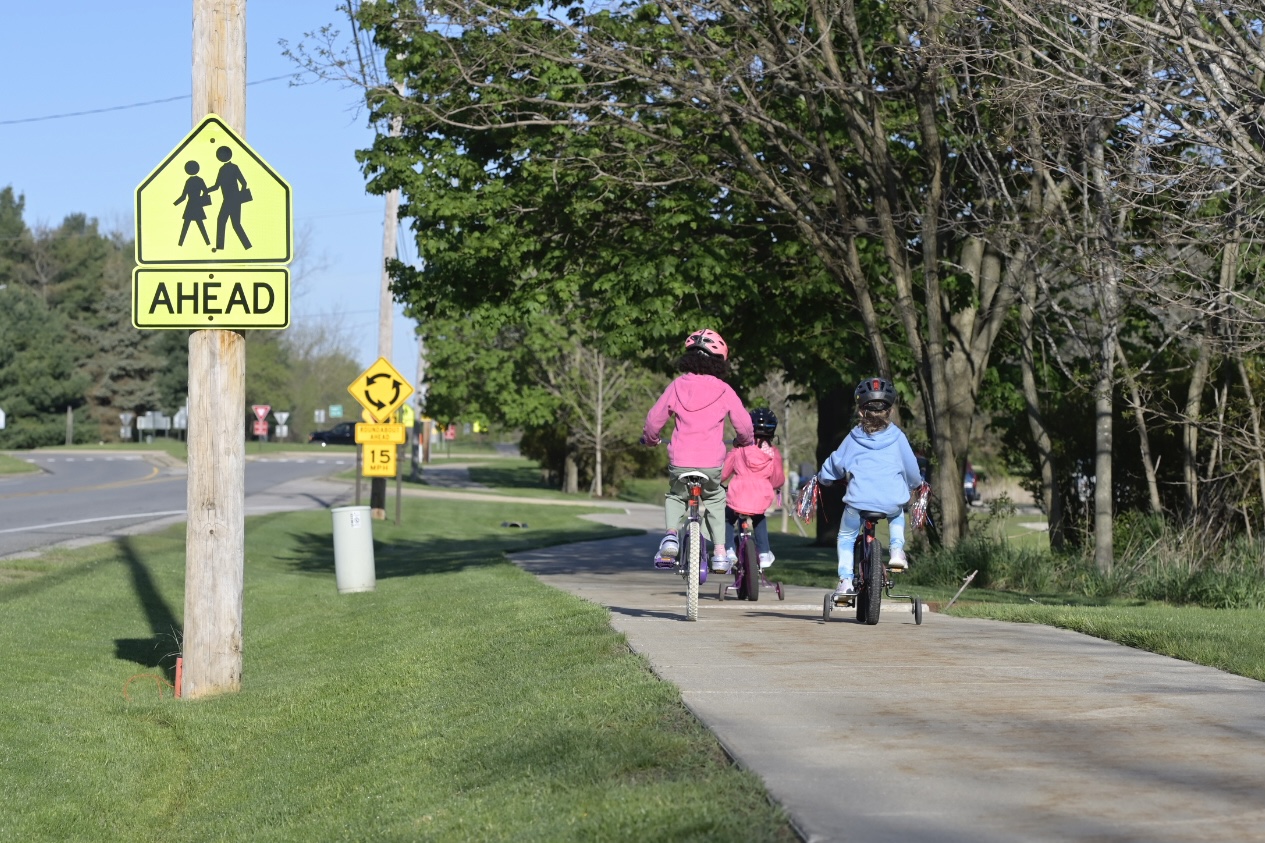 Children riding bikes to school on biking path