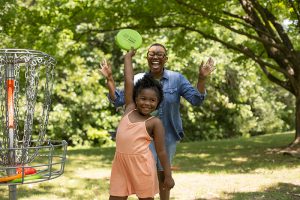 Family enjoying a game of disc golf by Michigan Fitness Foundation