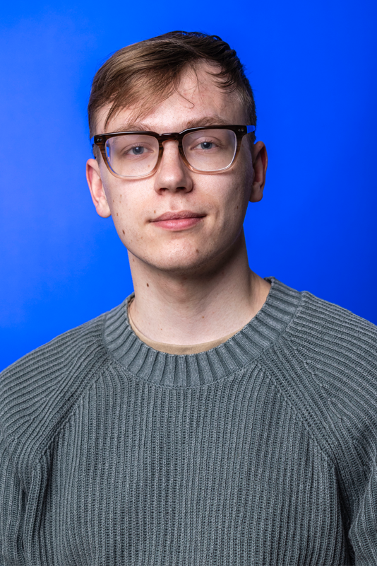 Evan Stowell headshot on blue background