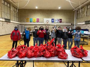 Students with a pile of red bags of produce