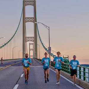three-men-running-over-mackinac-bridge