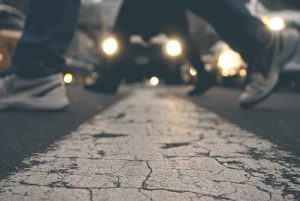 People's feet crossing the street at dusk